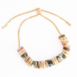 A gold-tone chain necklace with a curved row of marbled resin beads in earthy tones of brown, beige, and gray, accented by gold disc spacers, on a white background.